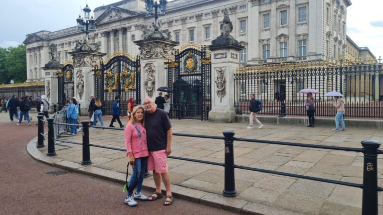 Tourists snapping photos outside Buckingham Palace with London taxi tours.