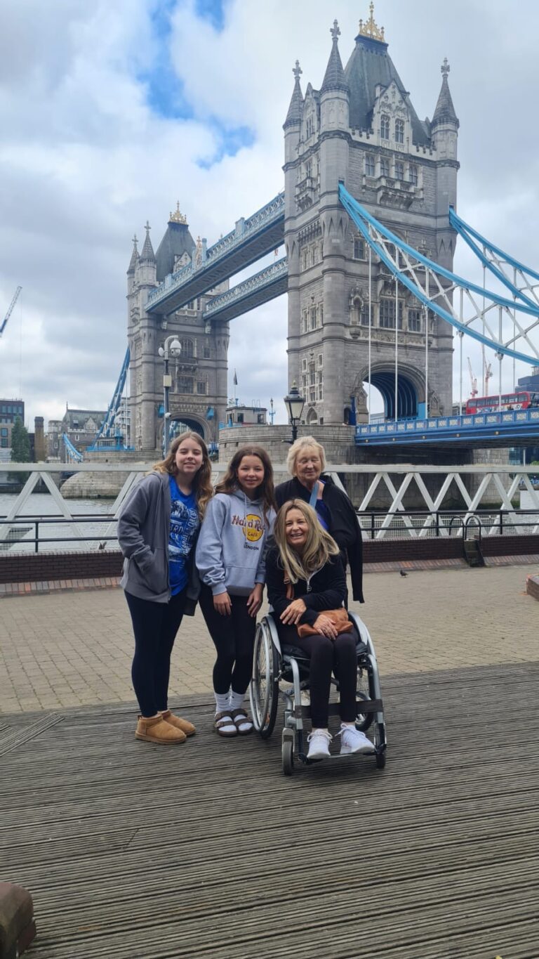 Tourists taking photos at Tower Bridge during London taxi tours.