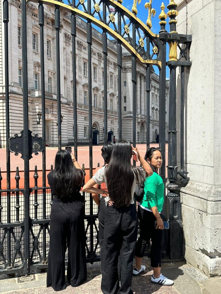 Tourists capturing London landmarks from a black cab taxi during a sightseeing tour.
