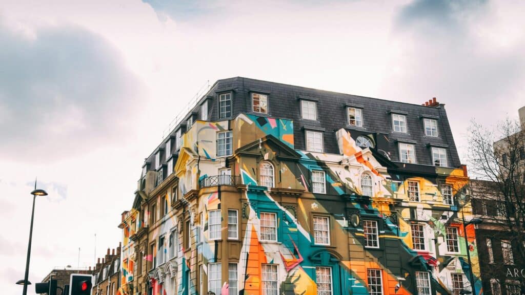 Black taxi driving through colorful Shoreditch street art scene