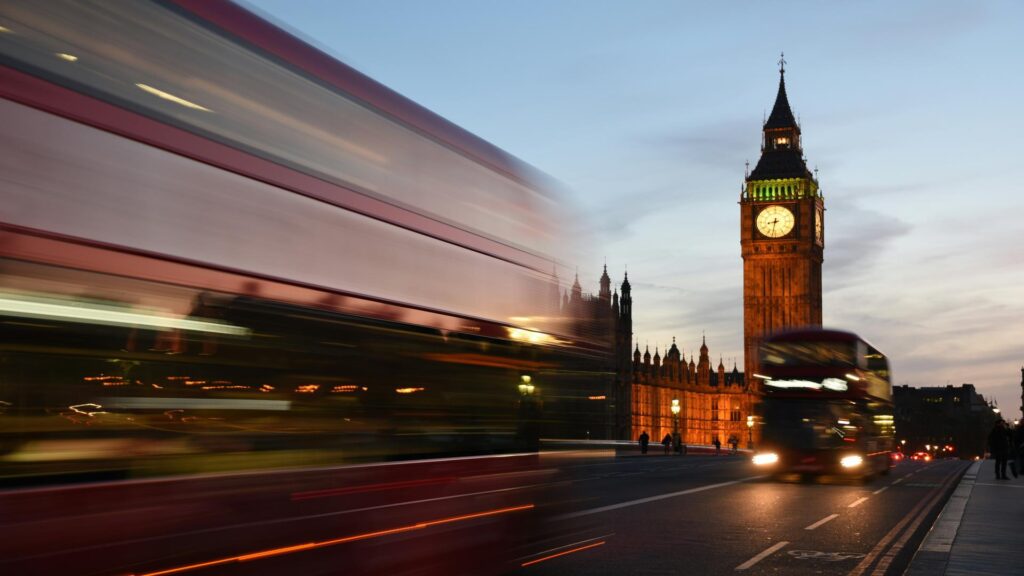 Black cab driving past Big Ben with luggage