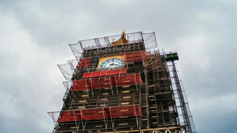 Big Ben clock tower covered in scaffolding during restoration work with iconic clock face visible