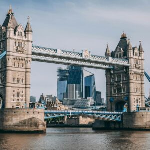 Tower Bridge in London with a boat on River Thames, modern city skyline in background