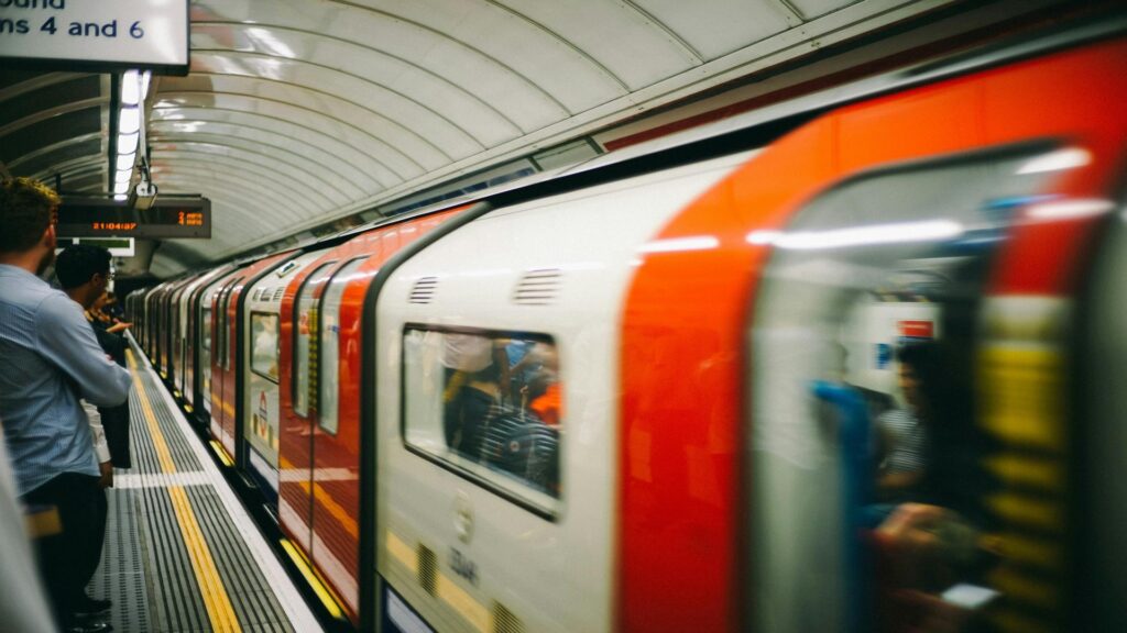 People waiting at a subway station with a train arriving