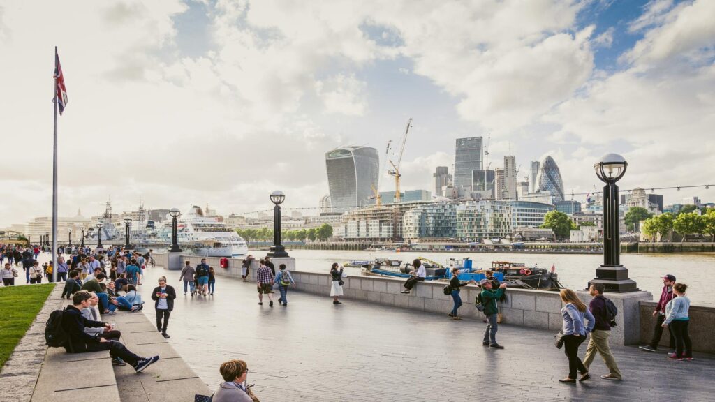 Man proposing to woman in front of London Eye with taxi in background