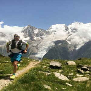 Trail runner on mountain path with Mont Blanc glacier views