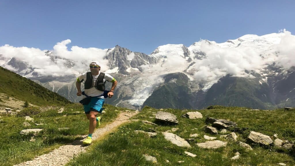 Trail runner on mountain path with Mont Blanc glacier views