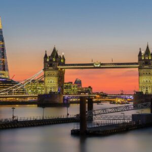 Tower Bridge and The Shard illuminated at sunset in London.