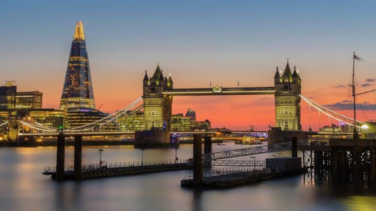 Tower Bridge and The Shard illuminated at sunset in London.