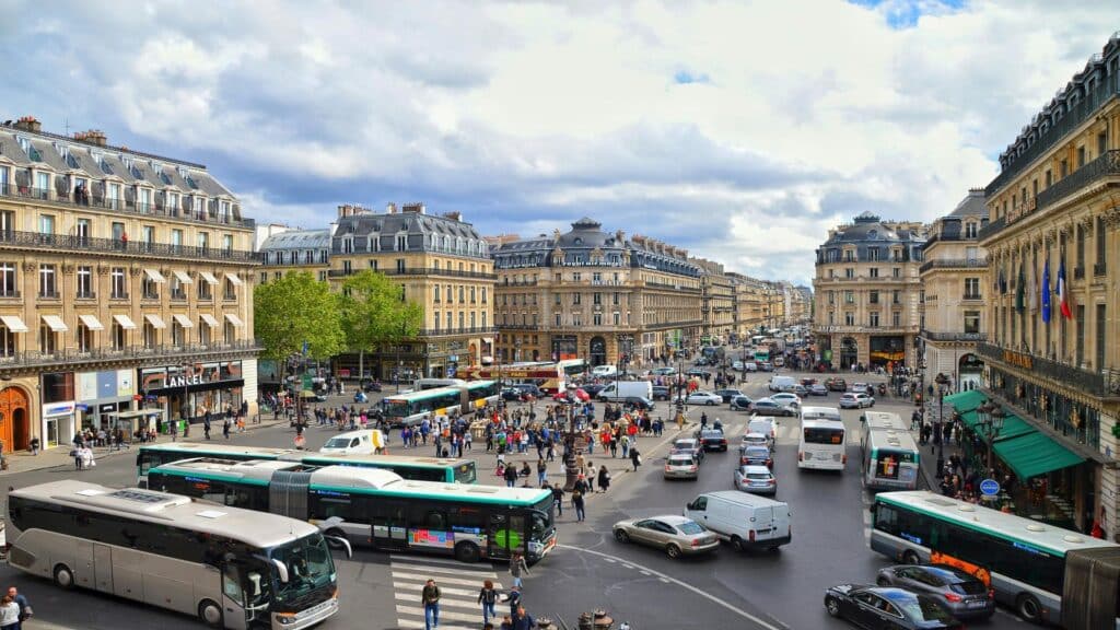 Busy city intersection with buses and pedestrians