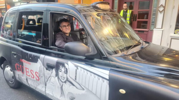 Black taxi promoting London sightseeing tours with wheelchair accessibility, showcasing Places To Go In London.