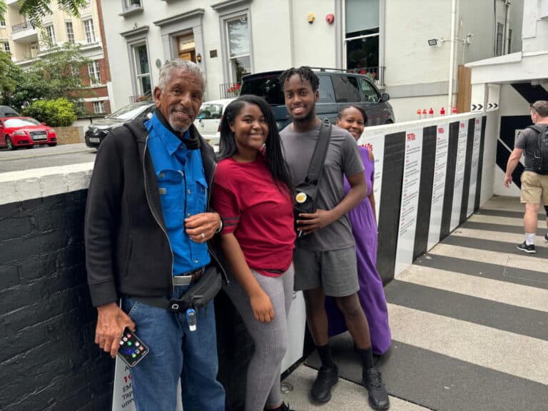 Multi-generational family enjoying attractions in London England during a black taxi tour, standing outside a historic building