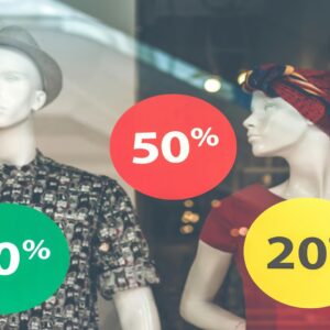 Store window display with two mannequins showing various percentage discounts - 50%, 30%, and 20% off