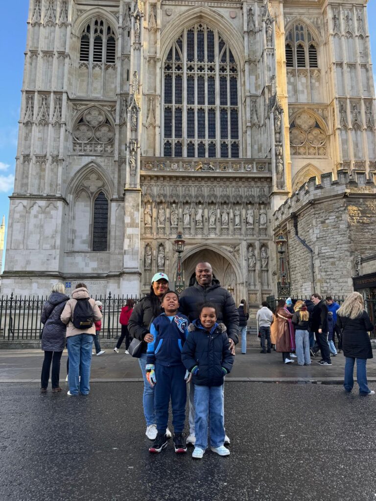 Family posing in front of Westminster Abbey, one of the must-visit London places