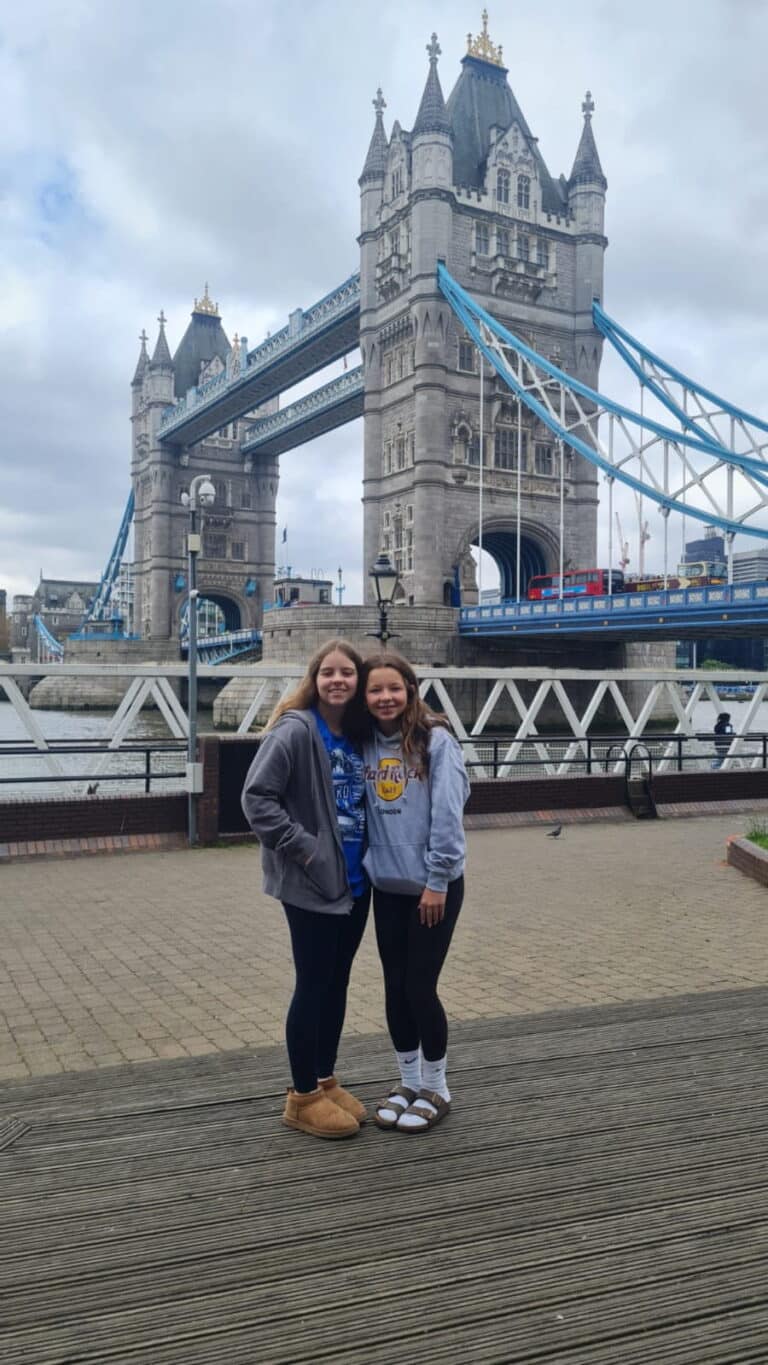 Visitors posing in front of Tower Bridge, a famous landmark in London, England