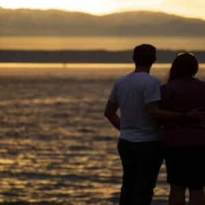 Couple watching sunset over the ocean