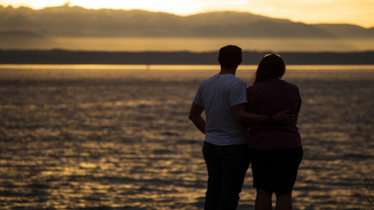 Couple watching sunset over the ocean