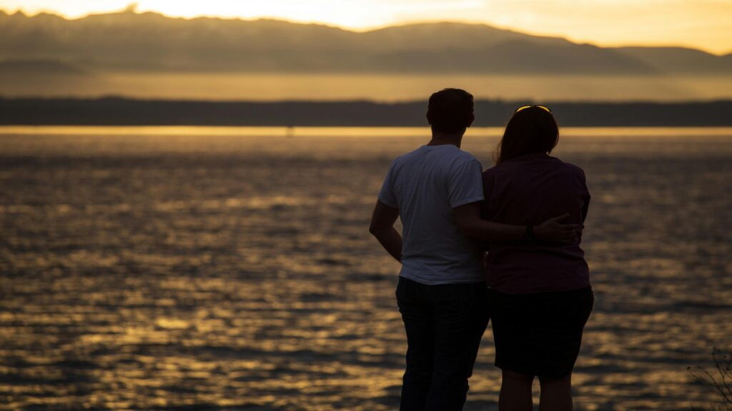 Couple watching sunset over the ocean