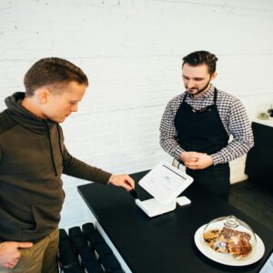 Customer interacting with a cashier at a cafe counter