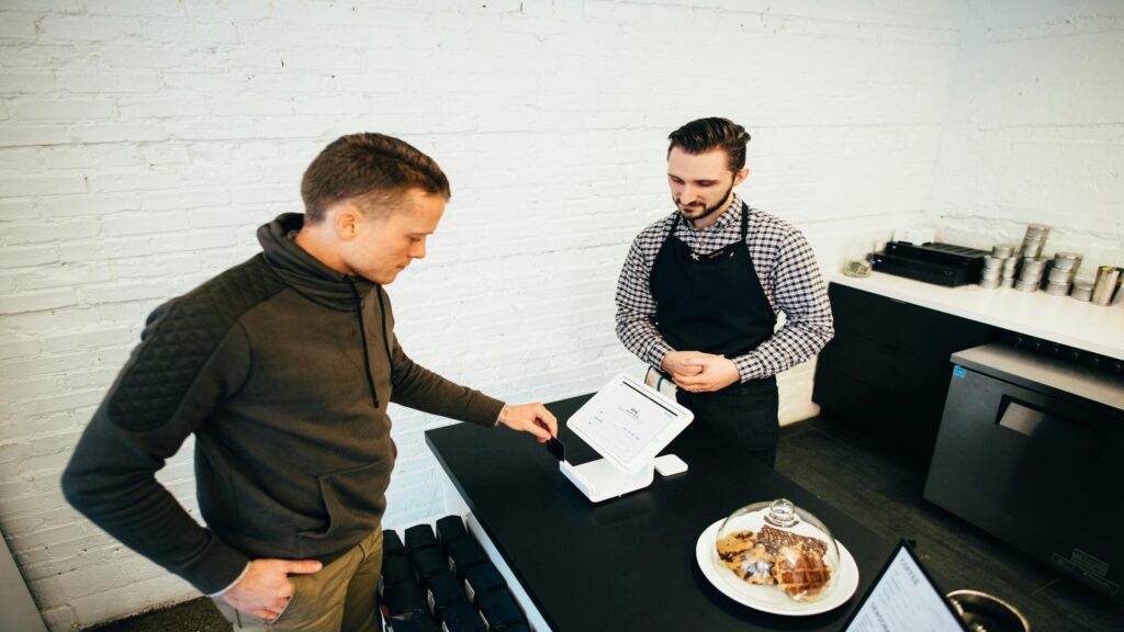 Customer interacting with a cashier at a cafe counter