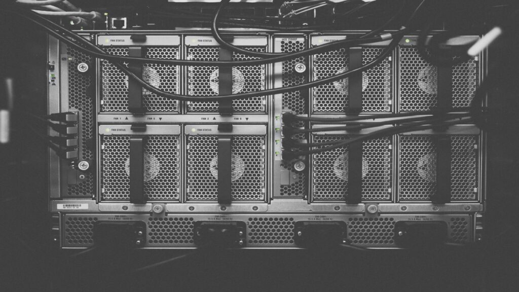 Close-up black and white photograph of server rack cooling fans with honeycomb ventilation grilles