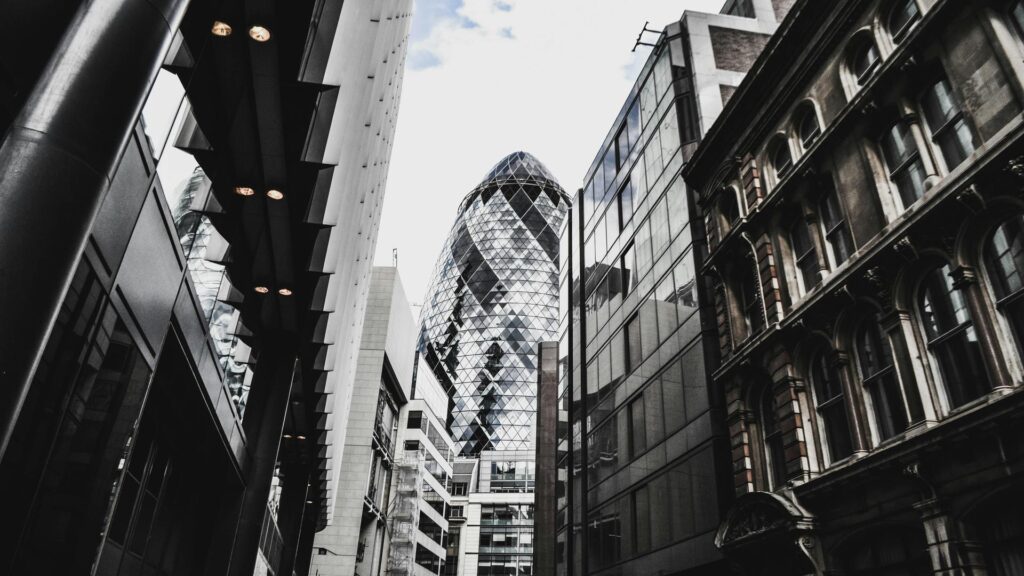 View of the Gherkin building surrounded by modern and historic architecture in London.