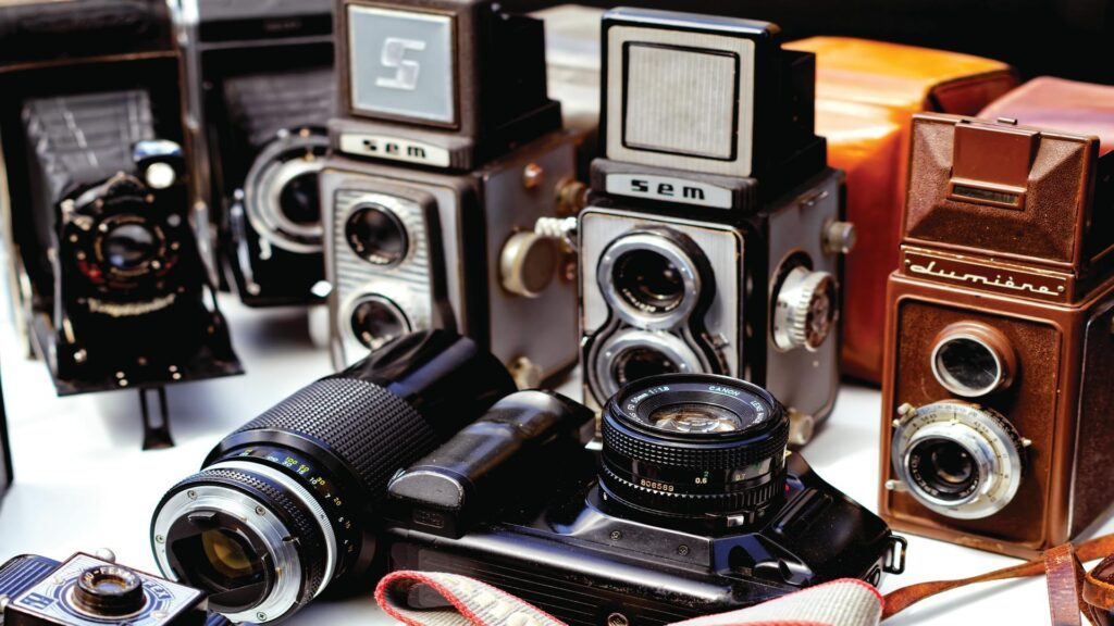 A collection of vintage cameras, including twin-lens reflex models and leather cases.