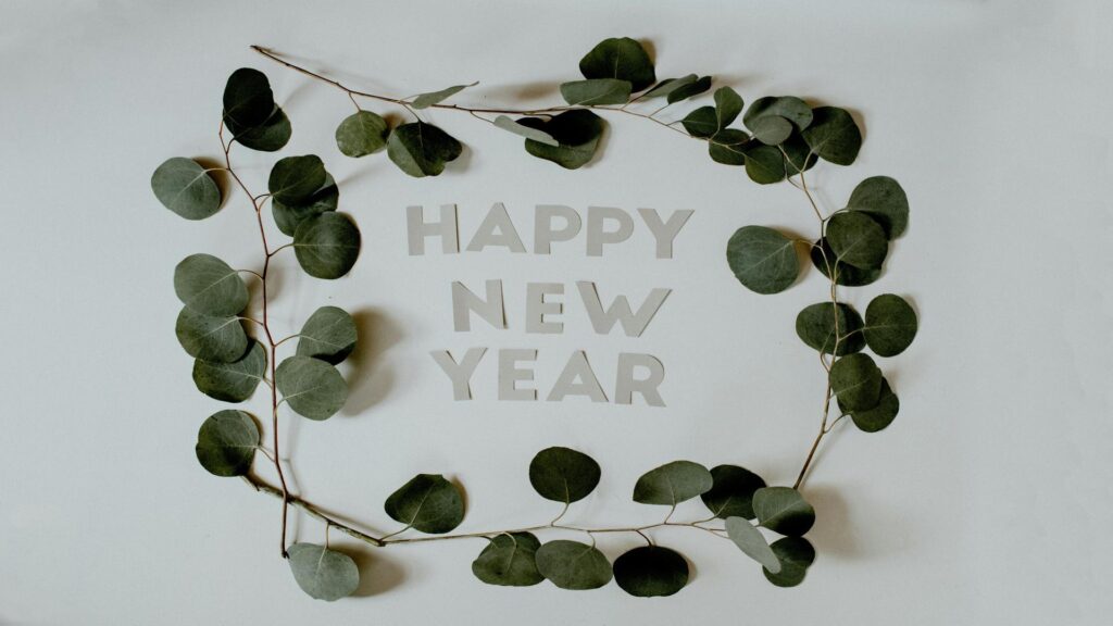 Happy New Year text surrounded by eucalyptus leaves