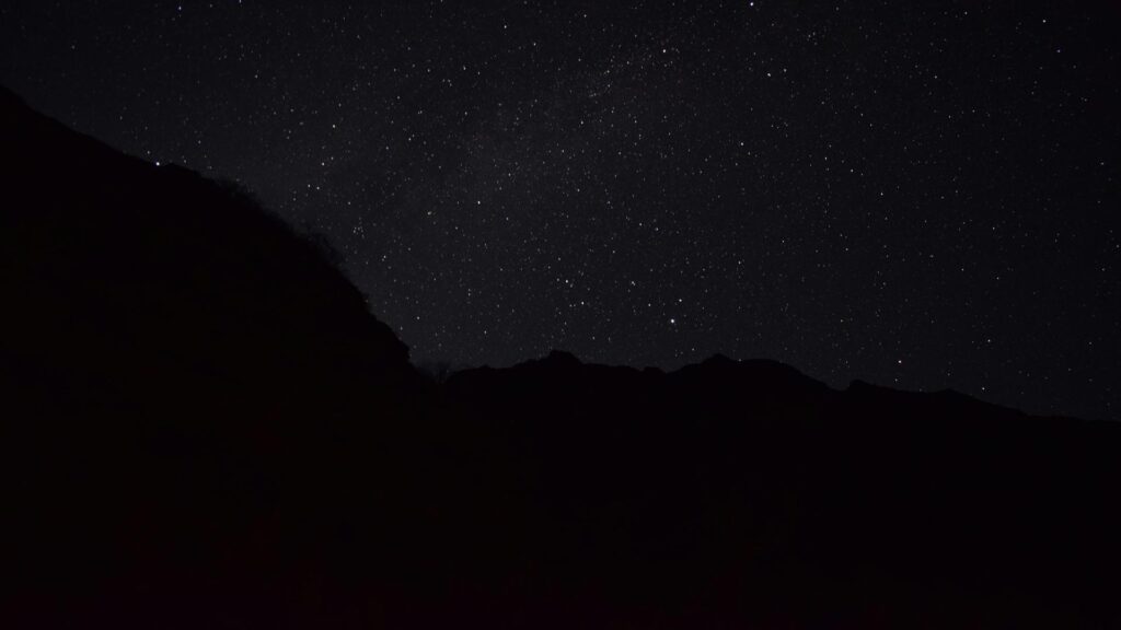 Silhouette of a mountain under a starry night sky captured during Stopover Tours