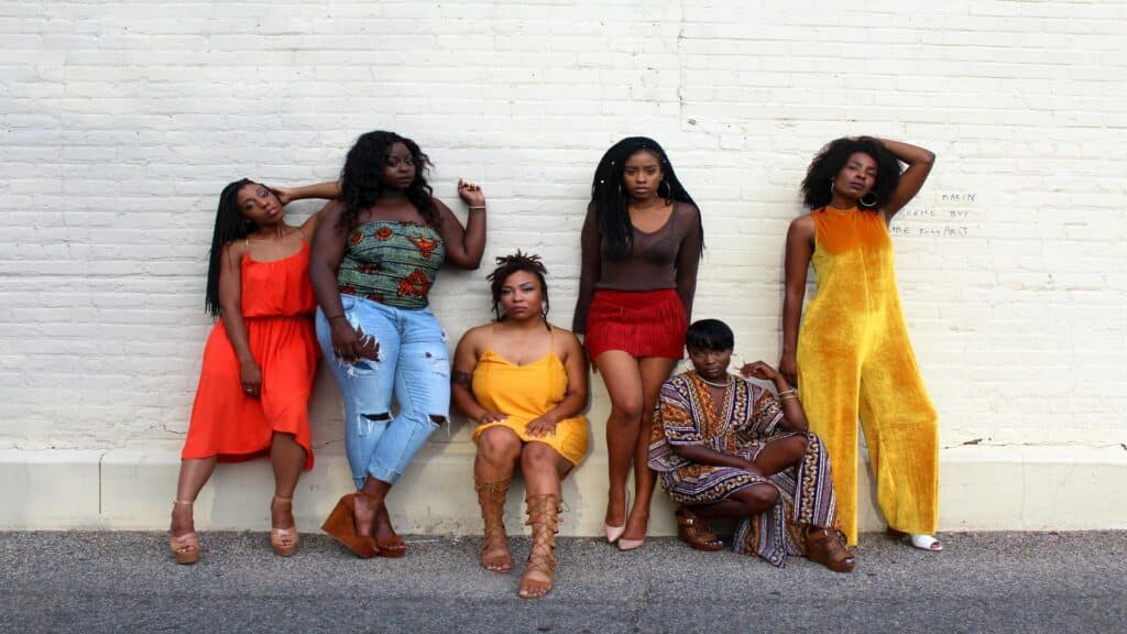 Group of women posing in vibrant outfits during an exhibition tour