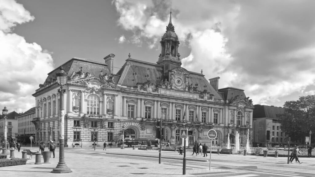 Black and white photograph of a grand French Baroque-style city hall building with ornate architectural details and a central clock tower