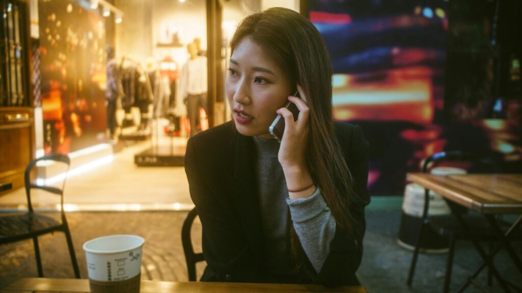 Person sitting at an outdoor cafe with a coffee cup