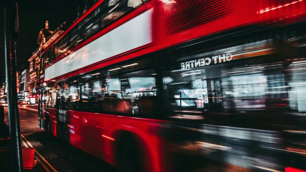 Blurred red double-decker bus at night