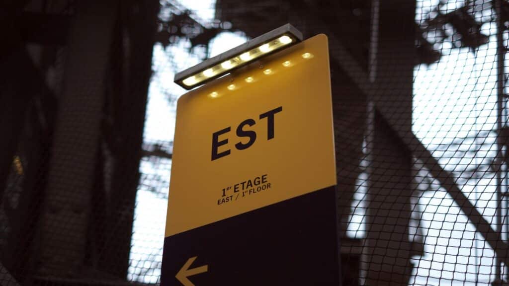 Yellow sign with 'EST' indicating east direction