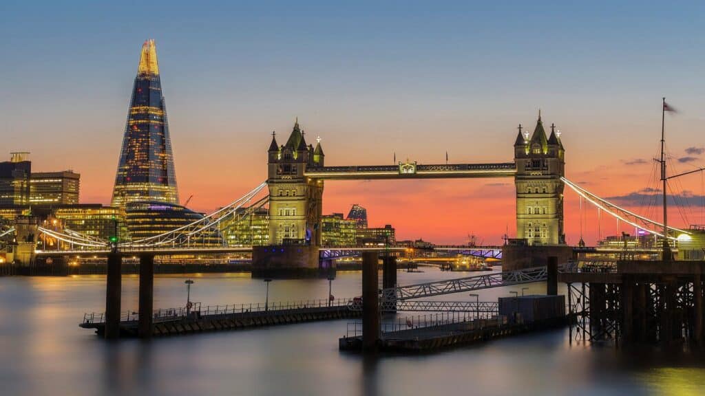 View of Tower Bridge and The Shard illuminated at sunset in London.