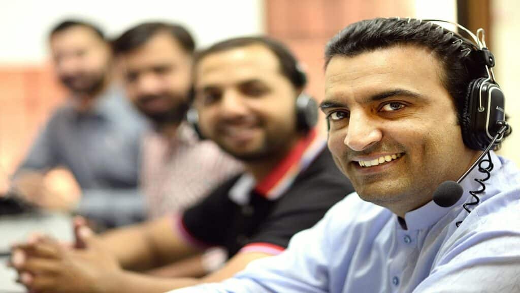 Group of people wearing headsets in a call center