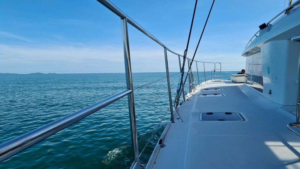 View from a yacht deck overlooking calm blue waters under a clear sky.