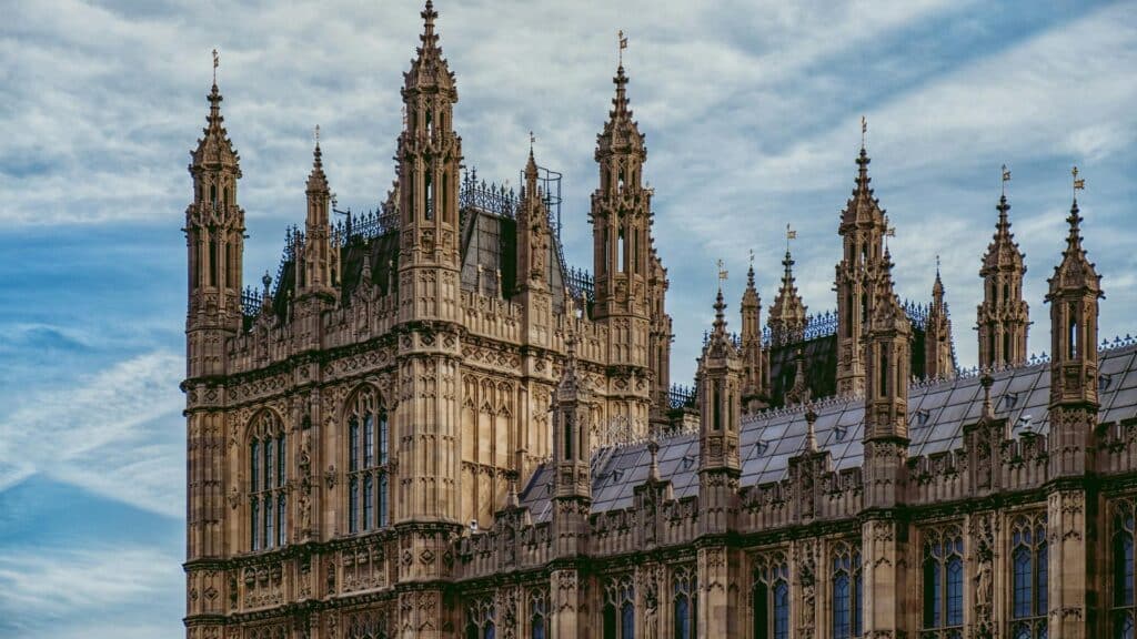 Close-up of the ornate Gothic spires of Westminster Palace against a cloudy sky