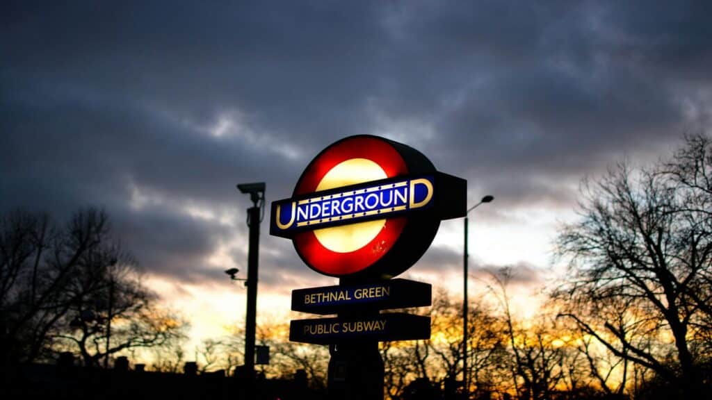 Illuminated London Underground sign at Bethnal Green station during sunset