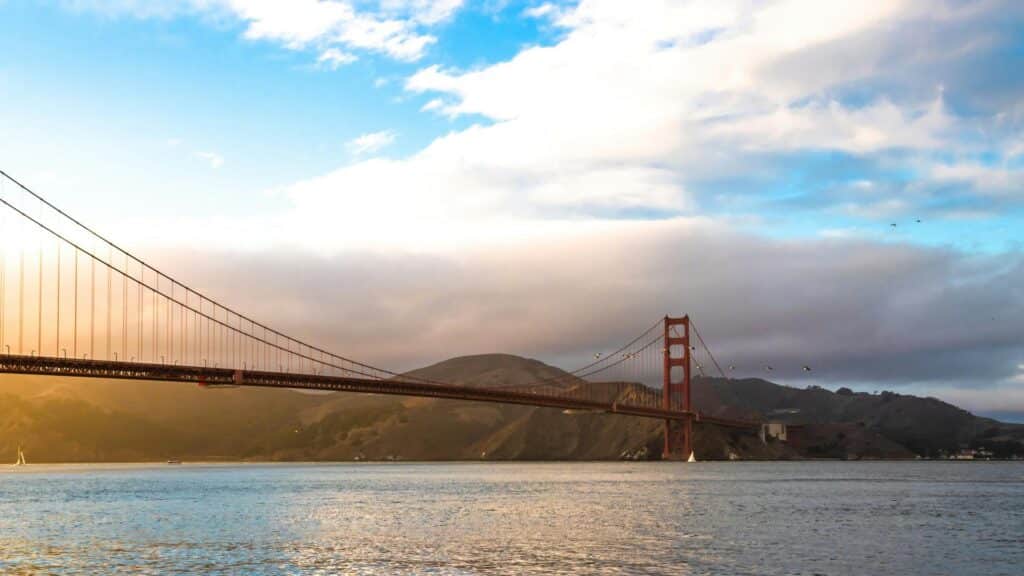 Golden Gate Bridge spanning across the water with a sunset backdrop