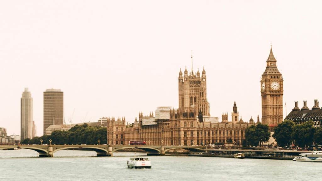 Iconic view of Westminster Palace and Big Ben along the River Thames in London with modern skyscrapers in background