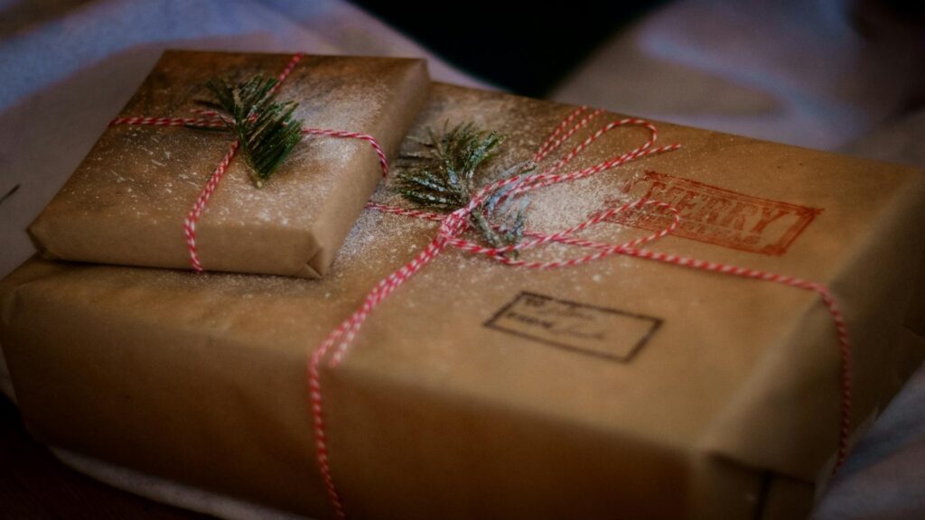 Beautifully wrapped Christmas gifts with twine and greenery.