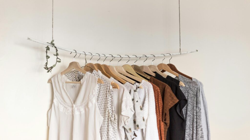 A minimalist clothing display on wooden hangers for exhibition tours