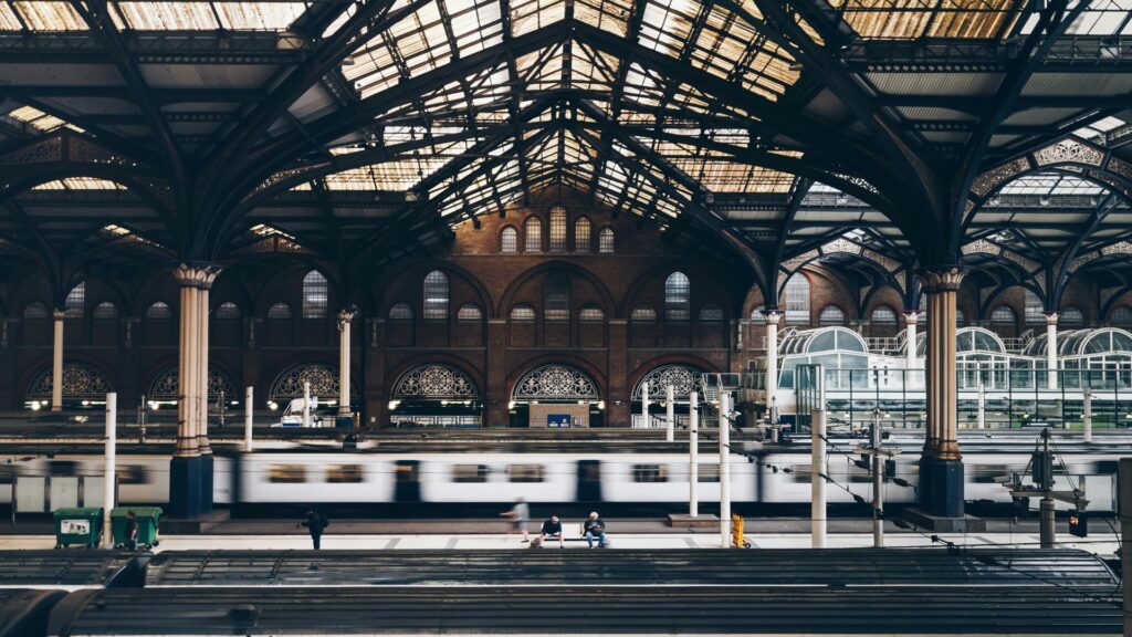 Interior view of a historic train station with a moving train