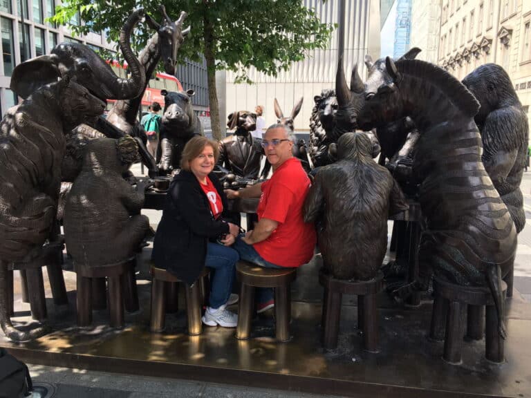 Visitors enjoying a Tower Of London Private Tour seated among animal sculptures in London.