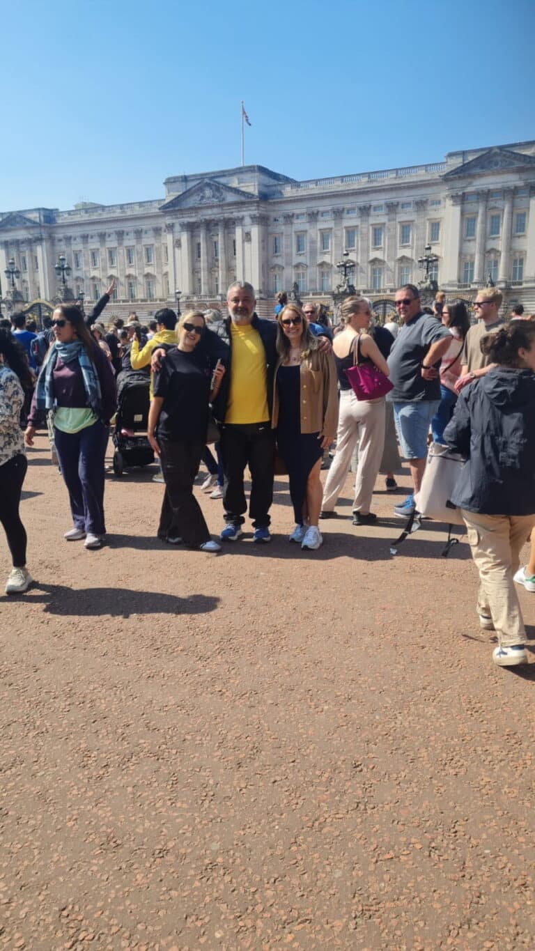 Visitors enjoying Top London Tours in front of Buckingham Palace