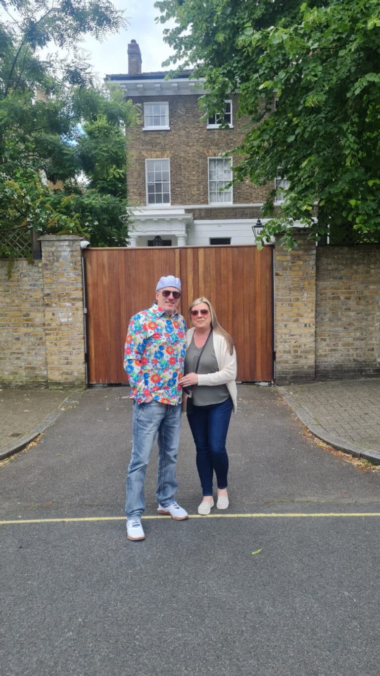 Tourists enjoying a London Sightseeing Taxi Tour in front of a classic London townhouse