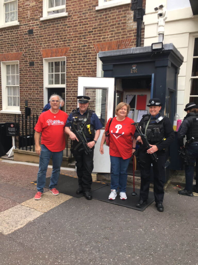 Tourists enjoying London Sightseeing Taxi Tours with armed police officers in front of a historic building - Best Way To See London