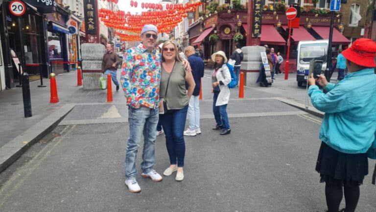 Tourists enjoying a sightseeing experience in London Chinatown under red lantern decorations, part of the Top 10 London attractions.