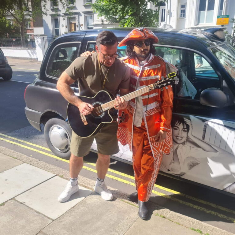 Two people enjoying a London One Day Tour Package with a sightseeing taxi in the background